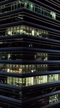 Dış pitoresk modern gökdelenler ile akşam ofislerinin parlayan pencere eşiği. Vurdu. Gece hayatı metropolis'kavramı. Gecede yüksek katlı binanın ofislerinin üstten görünüm.