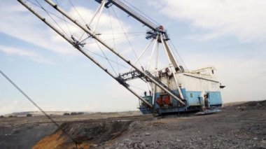 Güçlü bir kazıcı engin bir açık maden sahasında çalışıyor, dikkate değer endüstriyel verimlilik sergiliyor. Menkul Kıymetler