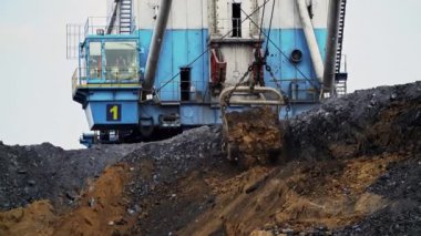 Güçlü bir kazıcı, bir madencilik operasyonunda verimli bir şekilde büyük miktarda toprak ve malzeme taşıyor.