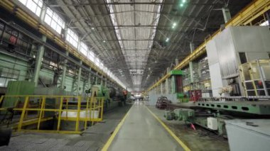 Geniş ve boş bir depo mükemmel ışıklandırma koşulları altında sergilenen çeşitli makineler sergiliyor.