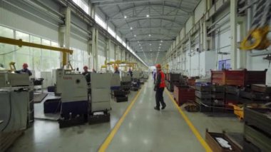 Endüstriyel bir ortamda çok sayıda işçinin ve gelişmiş makinelerin yer aldığı canlı ve hareketli bir üretim zemini. Menkul Kıymetler