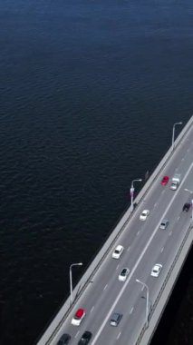 Kuş bakışı görüş. Şarjör. Okyanus üzerinde farklı yönlerdeki arabaların hareketleri için devasa bir köprü ve buradan geçen tekne ve gemiler görülebilir. Yüksek kalite 4k görüntü