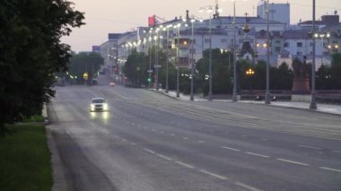 Sakin bir sokak manzarası, sakin bir şehir yolunu yakalıyor. Herkesin görebileceği şekilde alacakaranlıkta güzelce aydınlatılıyor.