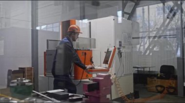 Otomatik makineler için kontrol paneli olan bir işçi. Borsa klipsi. Otomatik makineleri programlama ve fırlatma konusunda uzmanlar. Fabrikadaki kontrol panelleri robotik ekipmanlarla. 