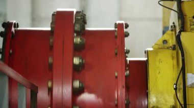 Kırmızı endüstriyel makine bileşeninin detaylı bir yakın çekim görüntüsü, cıvatalar ve karmaşık ekipman ayrıntıları. Menkul Kıymetler