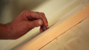 Yetenekli bir zanaatkar ahşap bir yüzeyi titizlikle işaretliyor ve ahşap işçiliğinde inanılmaz bir hassasiyet sergiliyor. Menkul Kıymetler