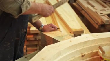 Çok yetenekli bir zanaatkar, parlak ışıklandırılmış atölye alanında çeşitli ahşap parçaları titizlikle birleştiriyor. Menkul Kıymetler