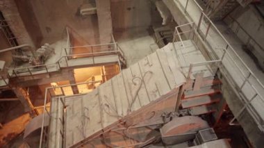 Havadan bakıldığında, bir üretim tesisinde tozlu bir ortamda çalışan bir taşıyıcı sistem görülüyor. Menkul Kıymetler