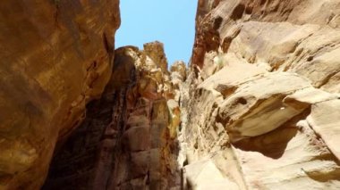 Kanyon duvarlarının çarpıcı görüntüsü berrak mavi gökyüzüne yükseliyor, canlı kaya oluşumları sergiliyor. Eylem