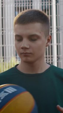 Sokaktaki sevimli sporcu. Medya. Parlak gözlü yakışıklı bir adam elinde voleybol topuyla oyun sahasında duruyordu. Yüksek kalite 4k görüntü