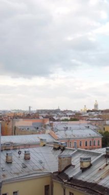 Bulutlu bir arka planda, yaz ayının güney şehrinin hava görüntüsü. Başla. Birçok binanın çatısı