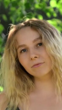 Yazın huş ağacında yaşayan güzel bir genç kadın. Kavram. Güneşli yaz gününde huş ağacının yanında parlak, çekici bir kadın. Sarışın güzel bir kadın yazın parkta gülümser..