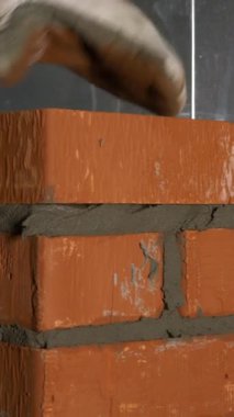 İnşaat süreci. Şarjör. Eldivenli bir adam, çimento takviyeli bir tuğlaya çabucak tuğla koyar. Yüksek kalite 4k görüntü