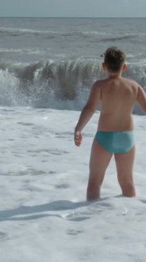 Çocuk yaz günü deniz dalgalarında eğleniyor. Yaratıcı. Tatil boyunca sıcak yaz günü