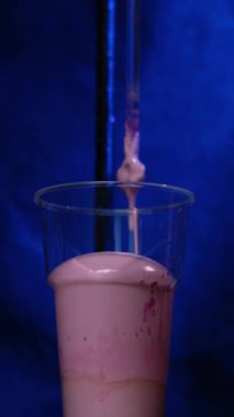 Volumetric flask kimyasal reaksiyon laboratuvarda cam. Kimyasal pembe reaktif şeffaf şişede. Kimyasal reaksiyon 4k