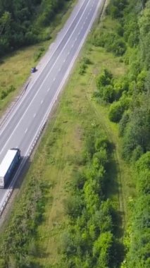 Üstten görünüm kırsal otoyol orman alanında. Küçük. Kırsal yol trafik otomobil ve kamyon ufukta şehre gidiyor. Seyahat ve ulaşım.