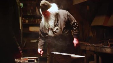 Demirhanesinde özenle çalışan yetenekli bir demirci. Etrafı çeşitli aletlerle çevrili ve dumanla kaplı. Menkul Kıymetler