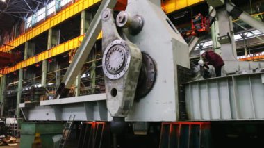Kalabalık bir endüstriyel atölye ortamında bulunan ağır makinelerin detaylı ve karmaşık bir görüntüsü. Menkul Kıymetler
