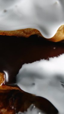 Yeni pişmiş tarçınlı dürümleri yakın çekim. Tatlı krem peynir kreması tarçınlı çörekler ve fırın ürünleri üzerine dökülüyor.