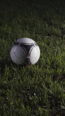 Futbol oyuncusunun çimlerin üzerinde topa vuruşunu yakından çek. Stok görüntüleri. Futbolcu geceleri stadyumda antrenman yapar. Futbolcu gece şampiyonada topa vuruyor..