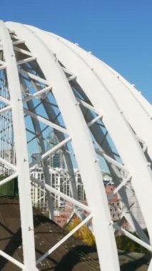 Beyaz kubbeli yapının üst görüntüsü. Stok görüntüleri. Yazın şehir merkezinde güzel, modern bir bina. Beyaz metal kemerlerden yapılmış modern sirk kubbesinin mimarisi..