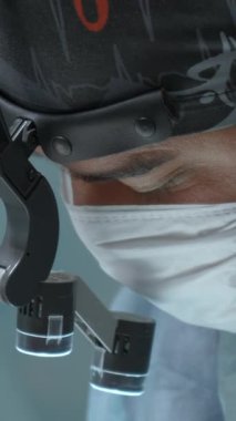 Doktorun ameliyat maskesini, steril maskesini ve koruyucu saç kılıfını kameraya bakarken yakından çek. Başla. Hastanede tıbbi malzemeler.