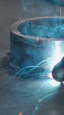 Kıvılcımlar ve metal halkayla yakın kaynaklama. Yaratıcı. Kaynak, kıvılcımlı metal halka. Fabrikada ya da demirhanede metal halkalı kaynaklardan kıvılcımlar çıkıyor..