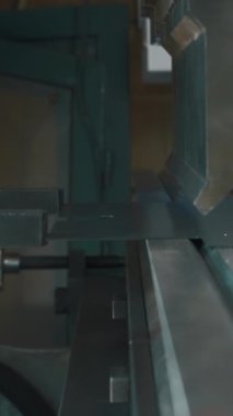 CNC bükme makinesinde metal levha bükme işlemi. Yaratıcı. Çalışanların elleri ve fabrikadaki ekipmanlar.