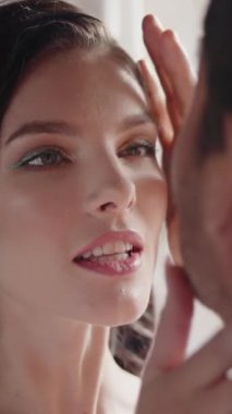 Genç ve zarif bir çift pencerede sarılıyor. Başla. Beyaz takım elbiseli güzel bir kadın ve güneş ışınlarının üzerine düştüğü bir adam. Yüksek kalite 4k görüntü