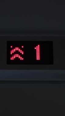 Kırmızı oklarla geçen kat numarasını gösteren bir asansör görüntüsü. Kavram. LED ekran, iç mekan