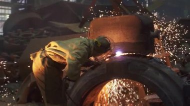 Canlı ve hareketli bir endüstriyel atölyede, yetenekli bir işçi titiz bir şekilde metali kaynaklıyor, parlak kıvılcımlar üretiyor. Menkul Kıymetler