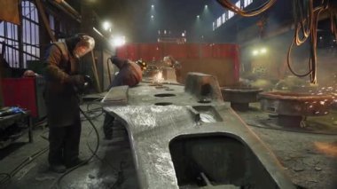 Yetenekli işçiler canlı, hareketli bir endüstriyel atölye ortamında metal parçalarını ustalıkla şekillendiriyorlar. Menkul Kıymetler