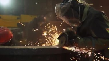 Yetenekli bir işçi, dinamik bir ortamda metal işçiliği yapar, kıvılcımlar saçar ve işçilik yapar. Menkul Kıymetler