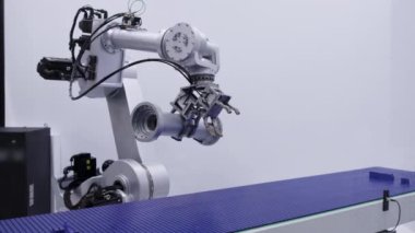 Parlak ve gelişmiş bir robot kolu modern ve modern bir çalışma alanı içinde verimli görevler yapıyor. Medya