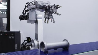 Modern bir endüstriyel ortamda görevleri yerine getirmek için özel olarak tasarlanmış ve donatılmış bir robot kol. Medya