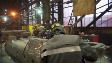 Yetenekli bir ekip, şafak vakti büyük bir endüstriyel tesiste metal parçaları ustalıkla kaynak yapıyor. Menkul Kıymetler