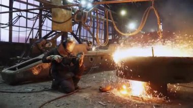 Metal işçiliğinin büyüleyici dinamik bir sahnesi, yoğun bir fabrika ortamında erimiş çeliğin kalıplara dökülmesiyle ortaya çıkıyor. Menkul Kıymetler