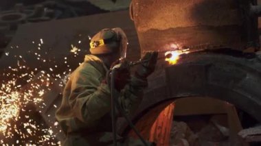 Bir zanaatkar yoğun bir endüstriyel ortamda kaynak yapar, kıvılcımlar yaratır ve olağanüstü beceri ve hassasiyet gösterir. Menkul Kıymetler