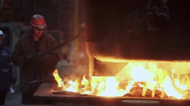 Yetenekli bir işçi yüksek sıcaklıktaki bir dökümhaneye erimiş metal dökme sürecini ustalıkla yönetir. Menkul Kıymetler