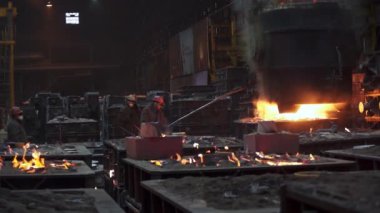 Büyük bir endüstriyel dökümhane içinde cereyan eden karmaşık çelik üretim sürecini gösteren büyüleyici bir görüntü. Menkul Kıymetler