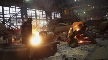 Metal işleme ve imalata katılan işçiler büyük bir endüstriyel tesis ortamında faaliyet gösteriyorlar. Menkul Kıymetler