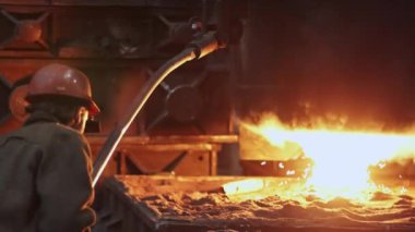 Yetenekli bir işçi, bir dökümhaneye dökülen erimiş metali titizlikle denetliyor ve olağanüstü bir işçilik örneği sergiliyor. Menkul Kıymetler