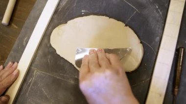 Kil ile ustalıkla çalışan bir insan, sanatın karmaşık ve hassas işleyişini gösteriyor. Menkul Kıymetler