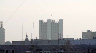 Şehir yaşamının ve mimarinin özünü güzel bir şekilde sergileyen puslu bir gökyüzü altındaki kentsel binaların uzak bir görüntüsü. Menkul Kıymetler