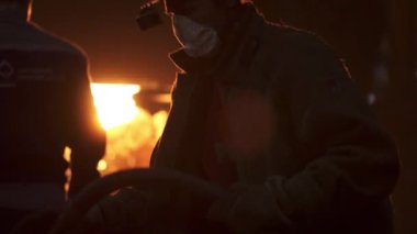 Yetenekli bir işçi, hayati güvenlik protokolleri ve endüstri uygulamalarını gösteren bir metal dökümhanesinde verimli bir şekilde çalışır. Menkul Kıymetler