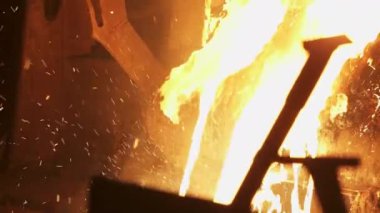 Metal atölyesinde, parlak kıvılcımların kızgın, parlayan bir fırının etrafında uçuşmasıyla büyüleyici bir sahne beliriyor. Menkul Kıymetler