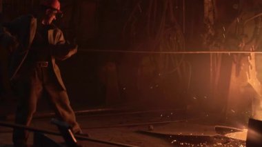 Loş bir atölyedeki erimiş metali ustalıkla idare eden yetenekli bir işçi olağanüstü bir endüstriyel işçilik sergiliyor. Menkul Kıymetler