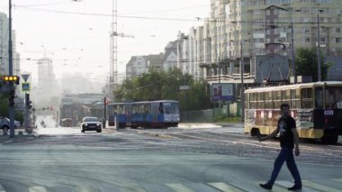 Tiflis, Gürcistan - 29 Eylül 2023: Yoğun sabah trafiğini ve caddeyi güvenle geçen bir yayayı zekice gösteren hareketli bir şehir manzarası. Menkul Kıymetler