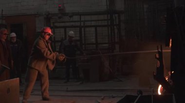 Fabrika ortamında metal döküm işlemi yapan işçiler endüstriyel işçilik ve takım çalışması sergiliyorlar. Menkul Kıymetler