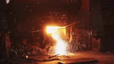 Kıvılcımlar ve ısıtmalarla çevrili canlı bir dökümhaneye dökülen erimiş metalin dinamik bir sahnesi, zanaatkarlık sergiliyor. Menkul Kıymetler